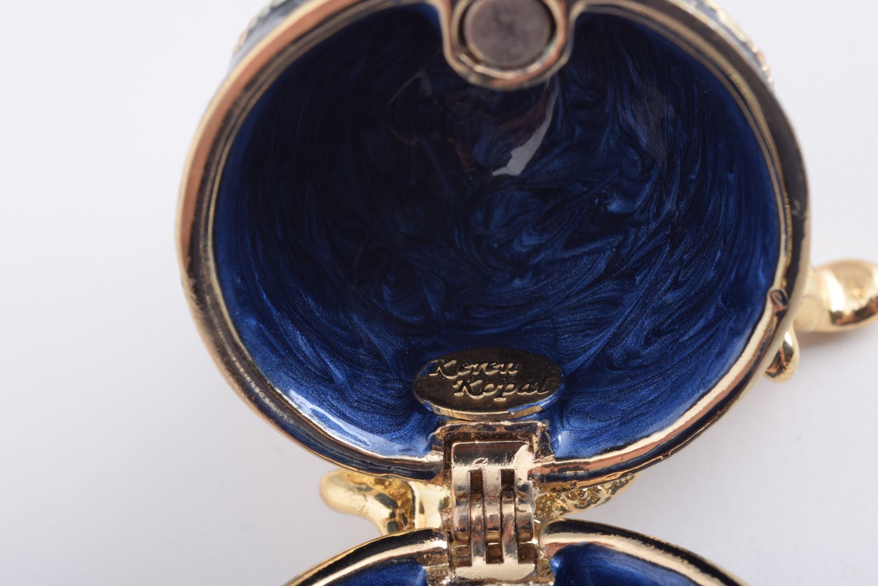 Oeuf Fabergé bleu et or avec une perle sur le dessus
