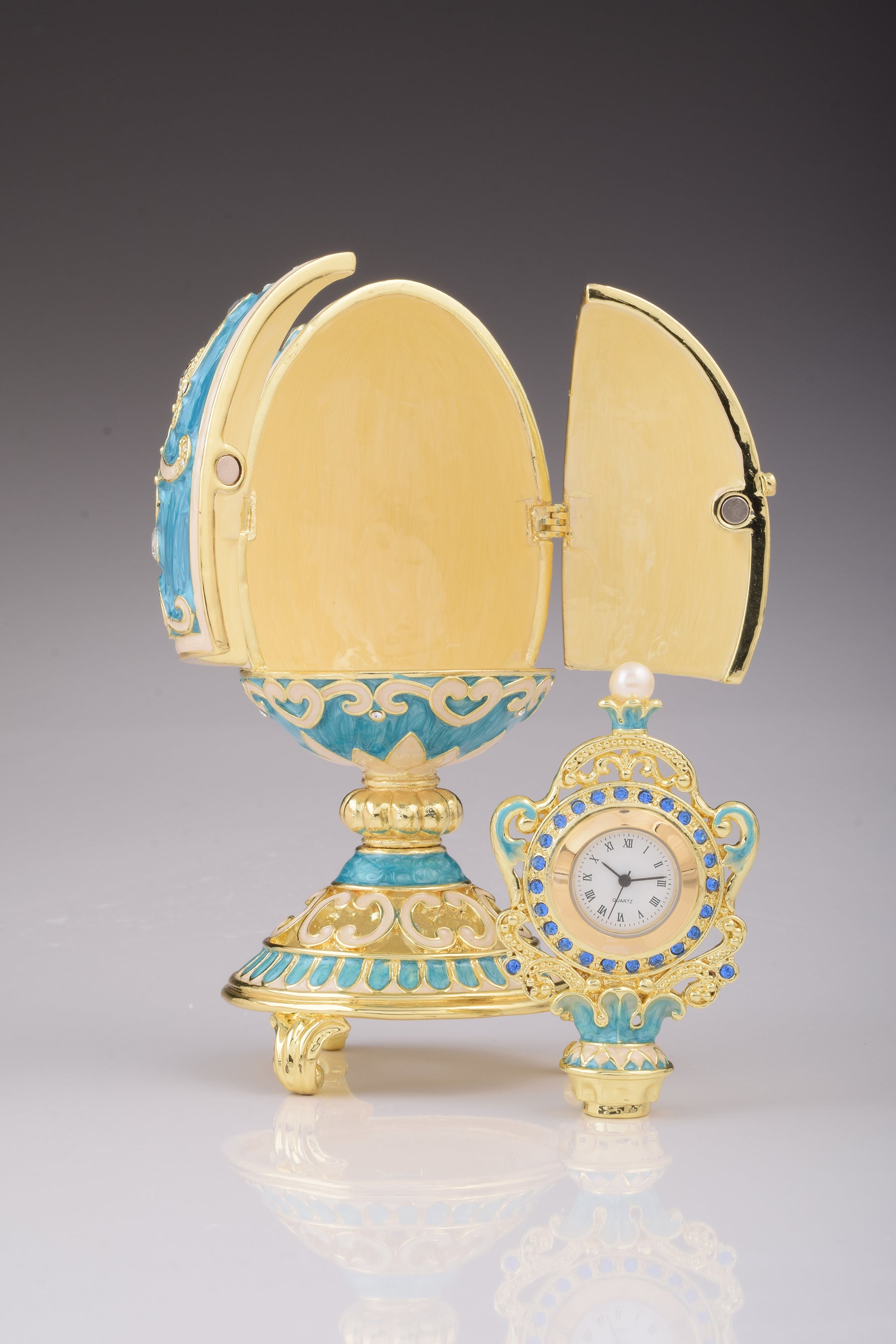 Oeuf Fabergé bleu sarcelle avec horloge à l'intérieur